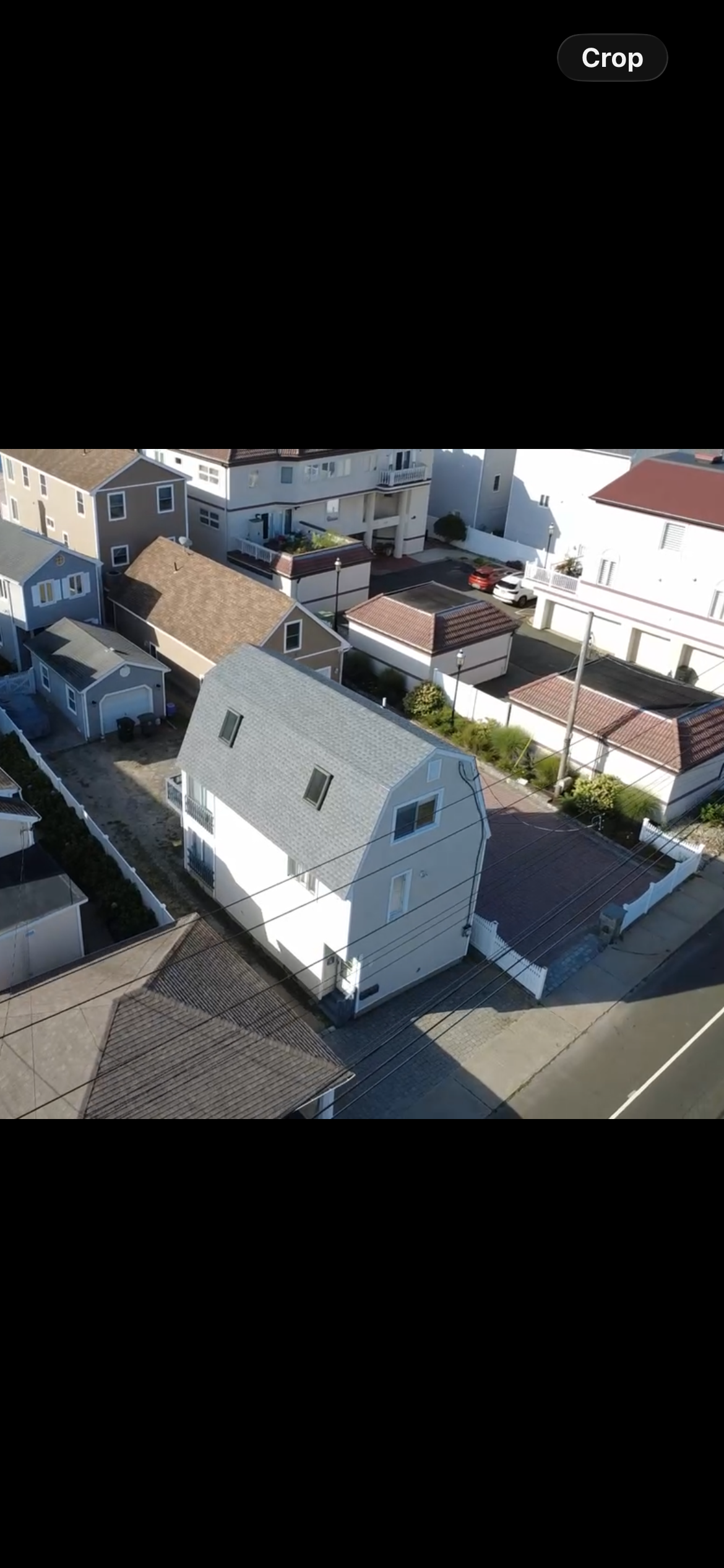 Dense neighborhood aerial showing a gray shingle roof replacement