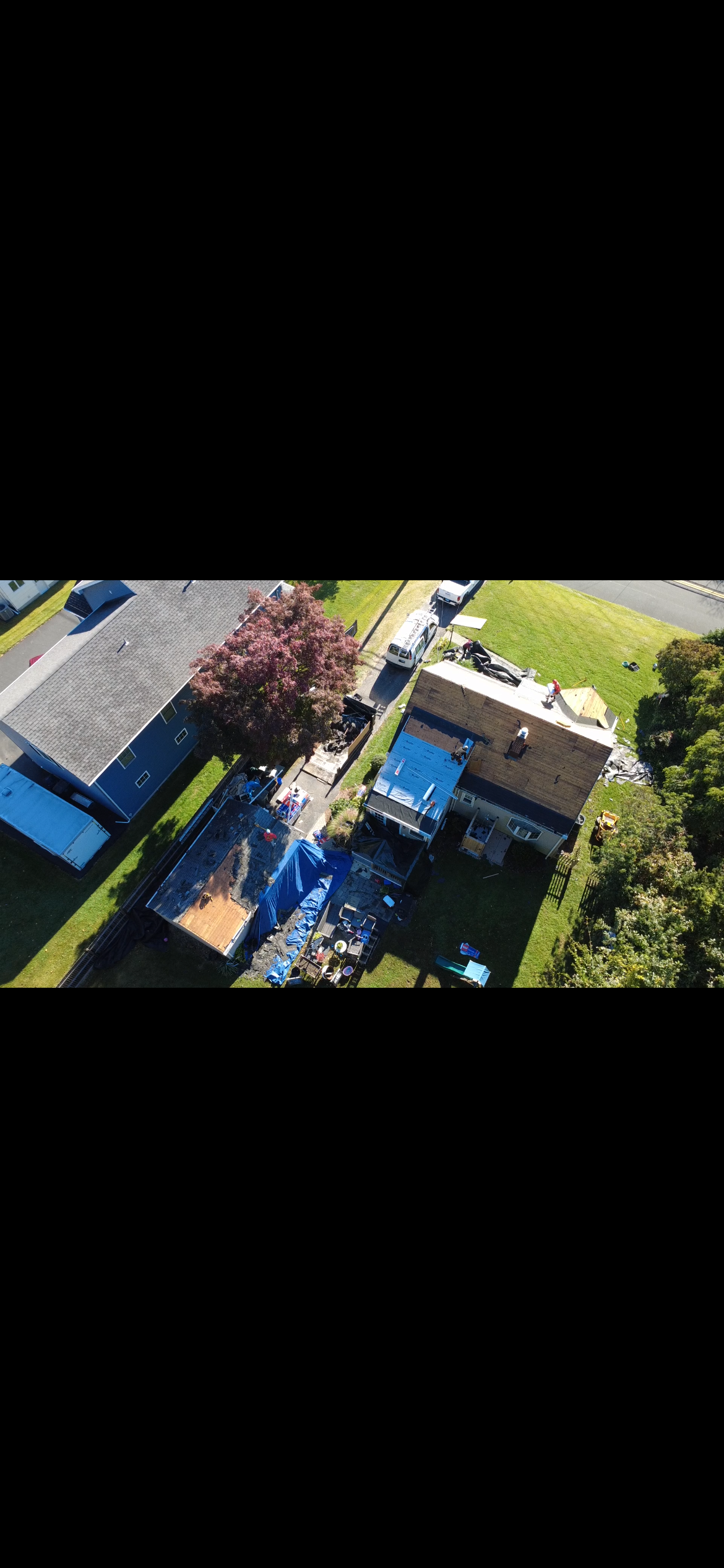 Roof mid-replacement with tarps and fresh shingles going on